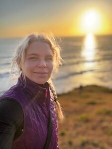 Abigail taking a selfie at the beach during sunset